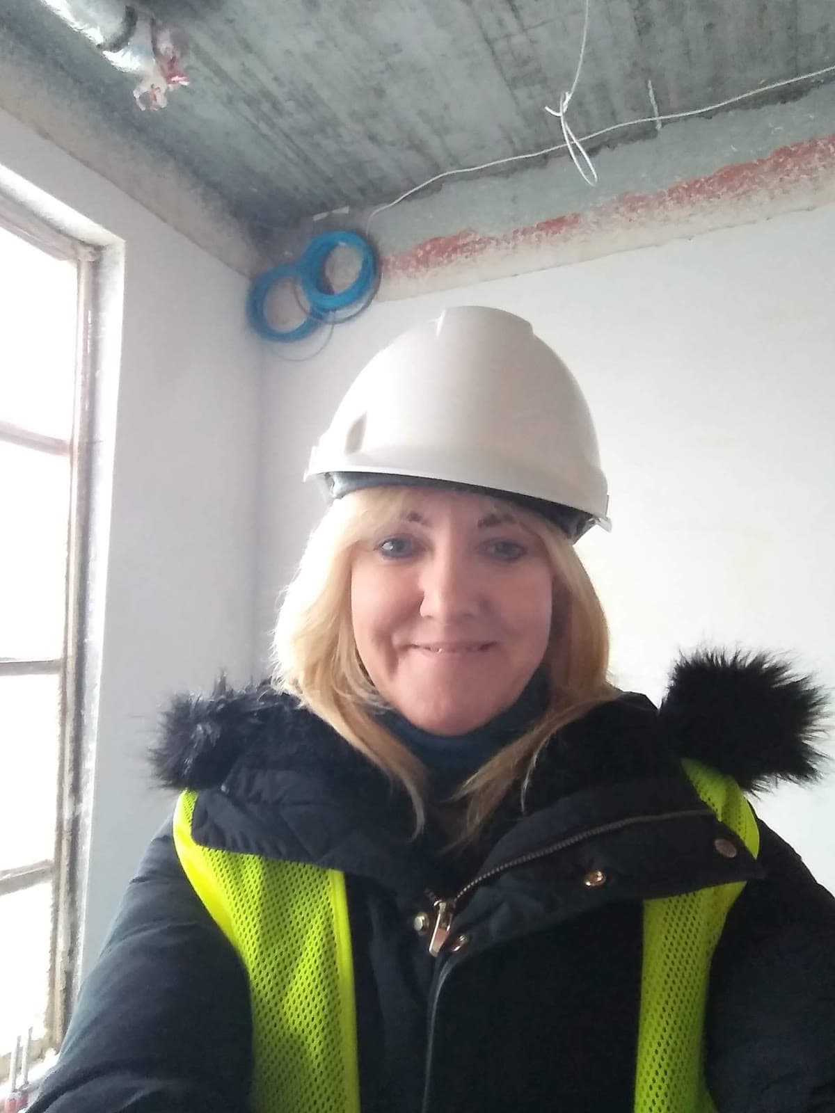 Monika Michałek w kasku ochronnym wewnątrz budynku w stanie surowym